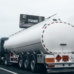 Caminhão-tanque visto por trás trafegando por uma rodovia para transportar combustível.