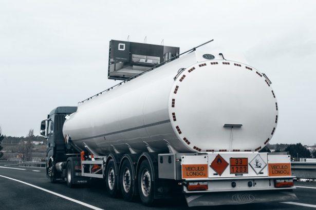Caminhão-tanque visto por trás trafegando por uma rodovia para transportar combustível.