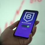 Mão segura um smartphone que exibe uma carteira digital de criptomoedas.