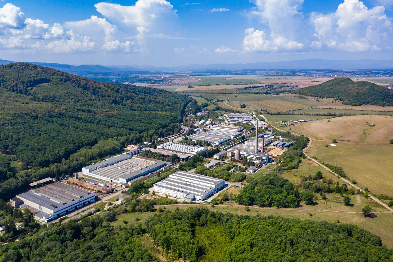 Vista de um parque industrial com fábricas e galpões em uma área próxima a uma cidade